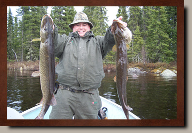 Man holding two muskie fish
